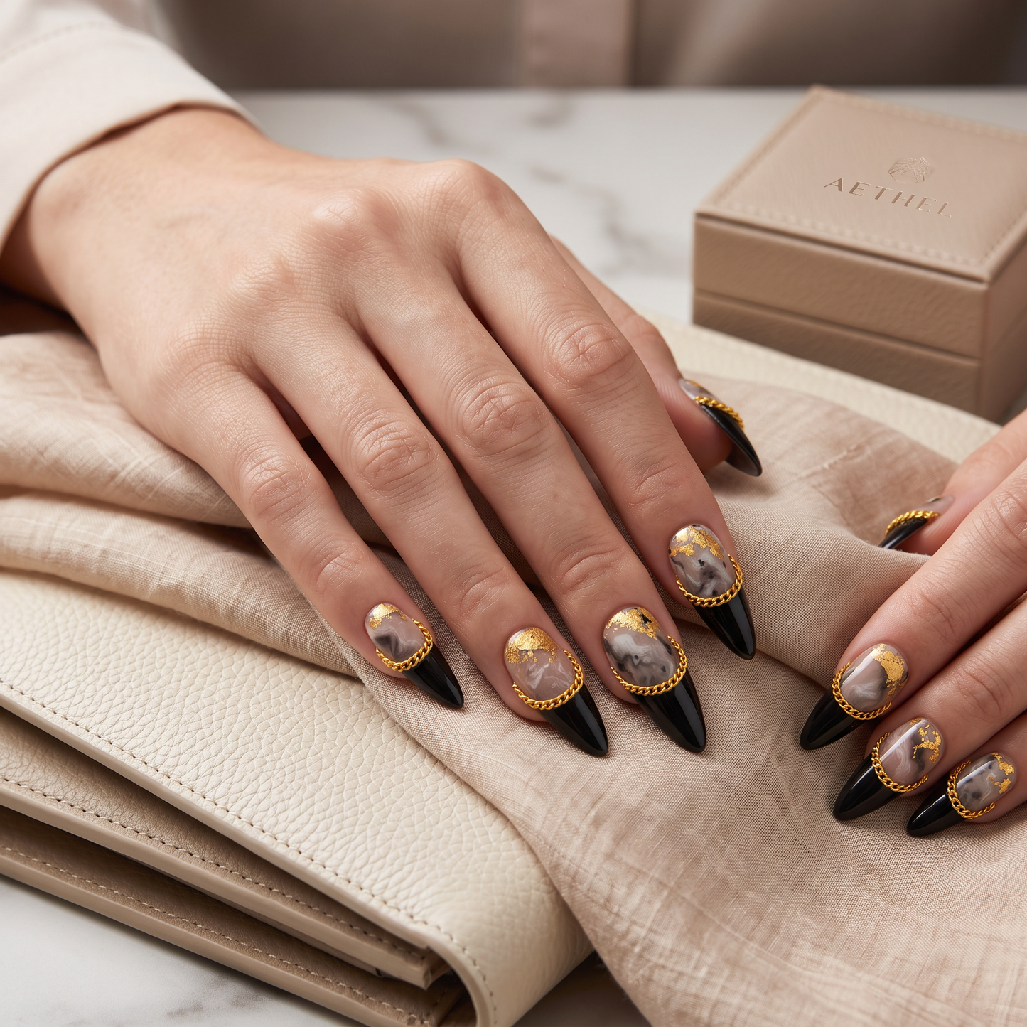 Auntie Cookies Nails Obsidian Reign almond-stiletto press-on nails with black, marble, gold leaf, and chain accents.