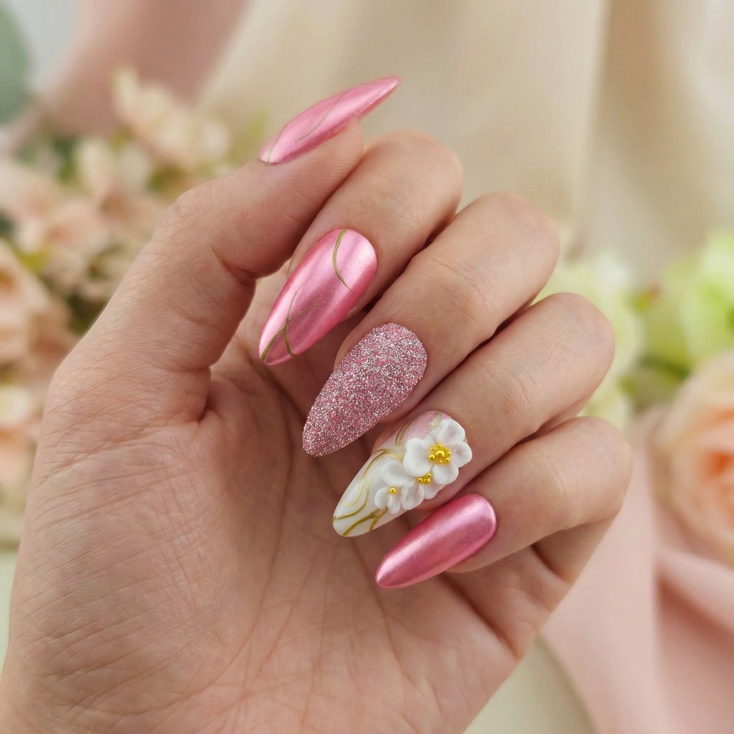 Auntie Cookies Nails: Pink chrome almond press-on nails with gold lines and 3D floral accent.