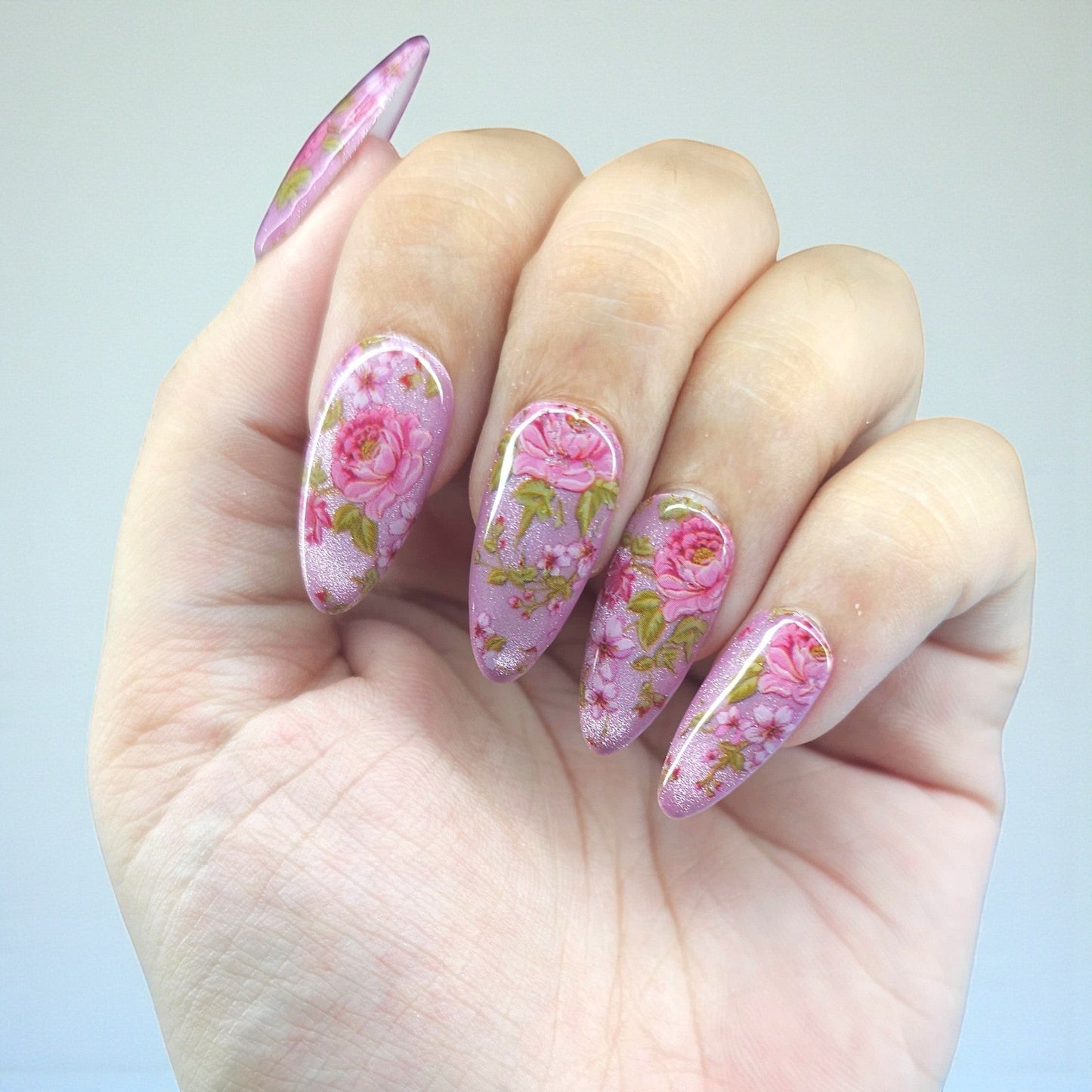 Auntie Cookies Nails Petal Prism almond-shaped press-on nails with pink and green floral design and shimmer.