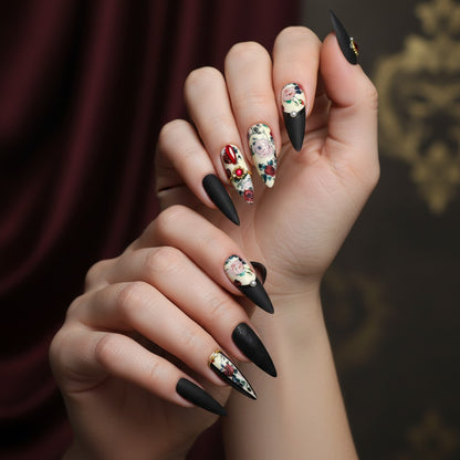 Auntie Cookies Nails: Set of 10 matte black almond-shaped press-on nails with floral and embossed designs, accented with pearls and rhinestones.