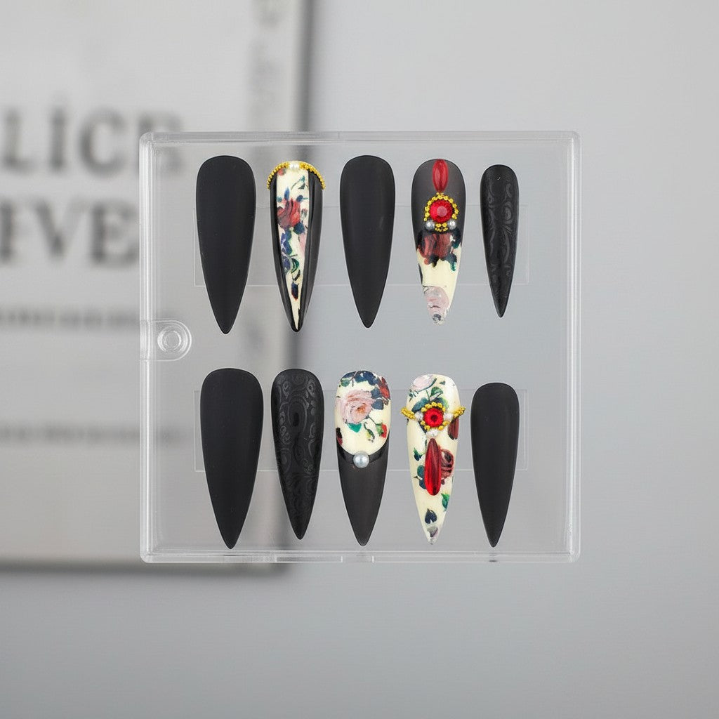 Auntie Cookies Nails matte black almond press-on nails with floral and embossed designs, accented with pearls and rhinestones.