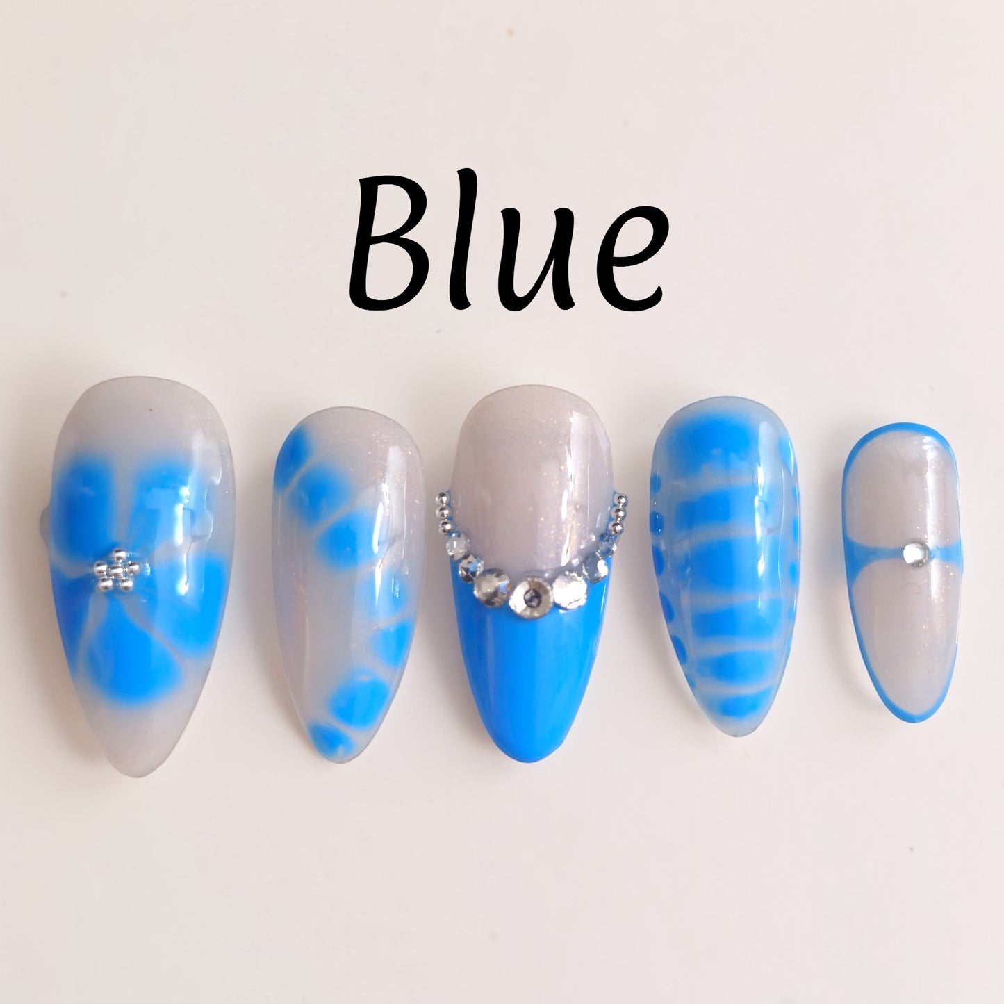 Auntie Cookies Nails: Set of 5 aqua lagoon press on nails with milky bases, blue accents, and crystal details.