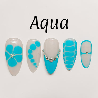 Auntie Cookies Nails: Set of 5 aqua and milky white press on nails with floral, dot, and abstract designs, some with crystals.