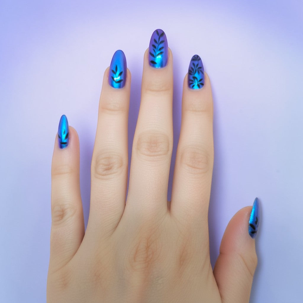 Auntie Cookies Nails: Blue iridescent stiletto press-on nails with black vine leaf design.
