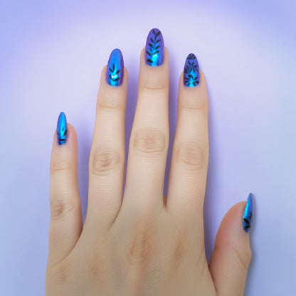 Auntie Cookies Nails: Blue iridescent stiletto press-on nails with black vine leaf design.