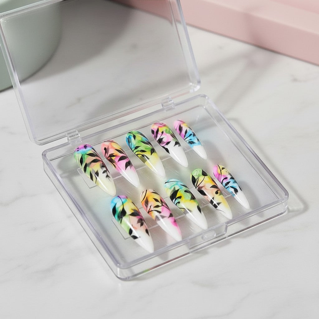Auntie Cookies Nails: Almond-shaped press-on nails with watercolor floral design in pink, blue, yellow, and green with black leaves.