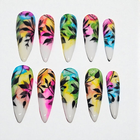 Auntie Cookies Nails: Almond-shaped press-on nails with watercolor-style pink, yellow, blue, and green abstract design and black foliage. Glossy finish.
