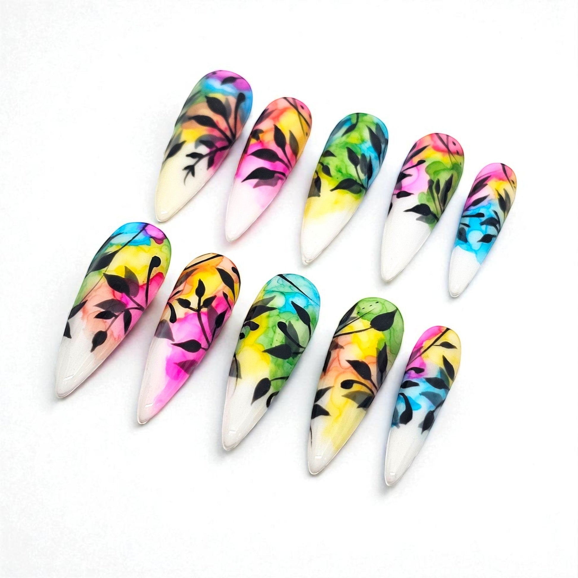 Auntie Cookies Nails: Almond-shaped press-on nails with watercolor-style colorful designs and black foliage accents.