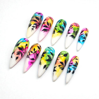 Auntie Cookies Nails: Almond-shaped press-on nails with watercolor-style colorful designs and black foliage accents.