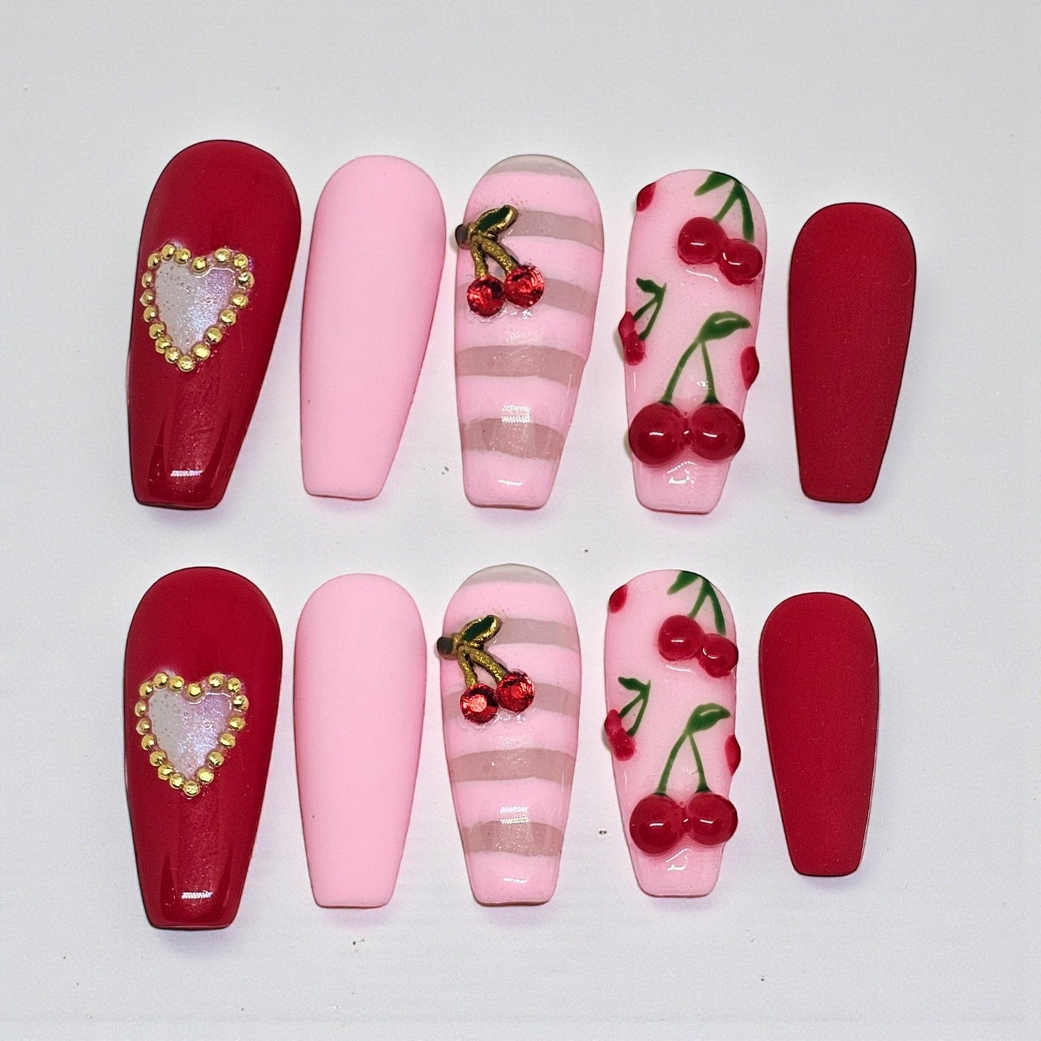 Auntie Cookies Nails: Coffin press-on nails in red, pink, and striped designs with cherry and heart charms.