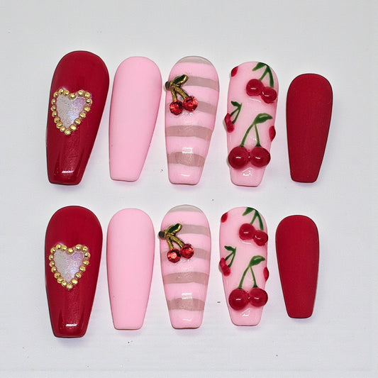 Auntie Cookies Nails: Coffin press-on nails in red, pink, and striped designs with cherry and heart charms.