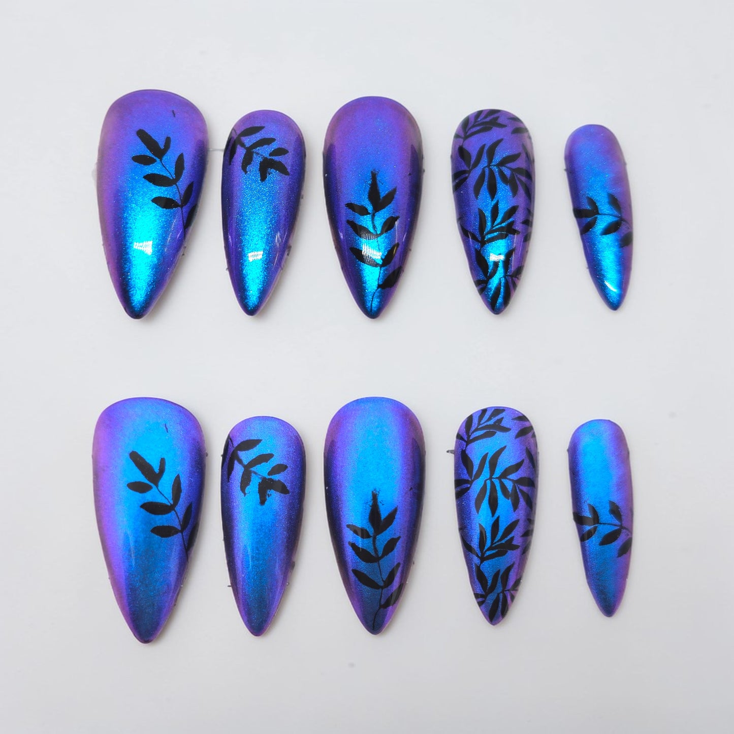 Auntie Cookies Nails Cosmic Vine press on nails, iridescent blue and purple with black vine design. Stiletto shape.
