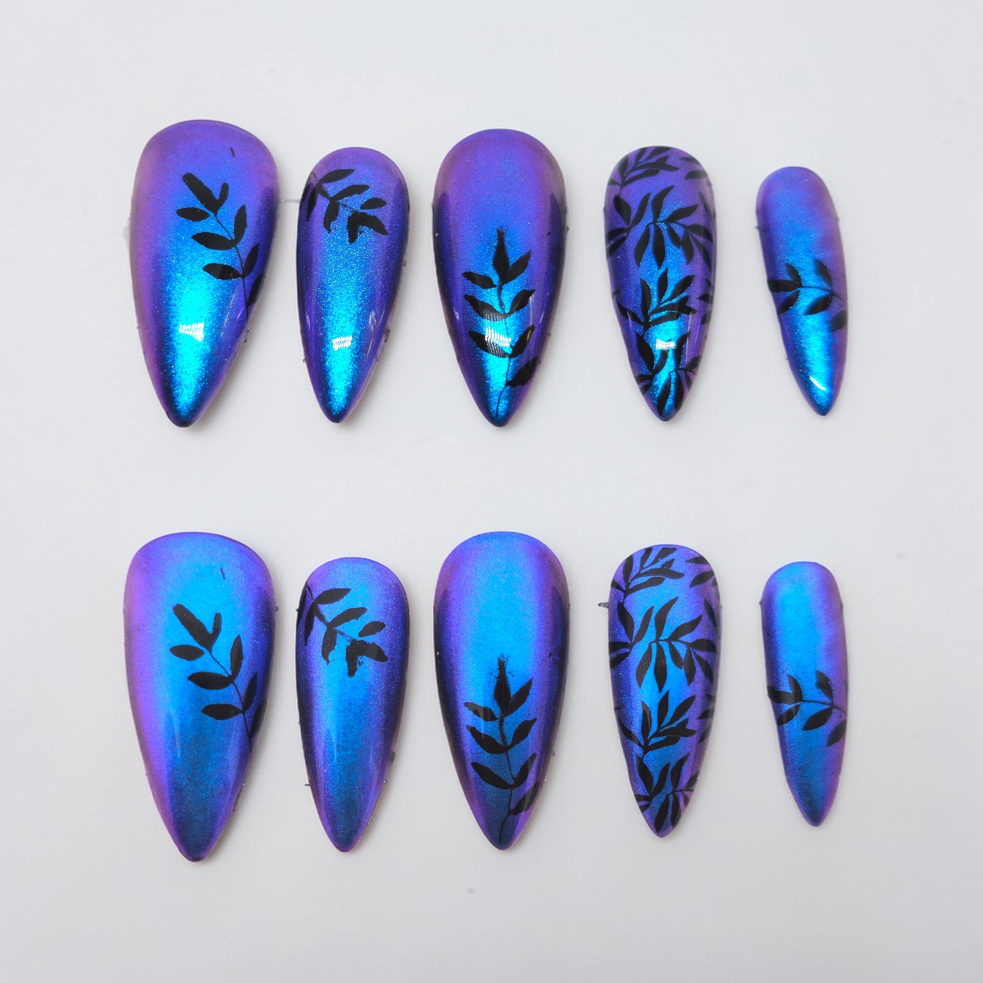 Auntie Cookies Nails Cosmic Vine press on nails, iridescent blue and purple with black vine design. Stiletto shape.