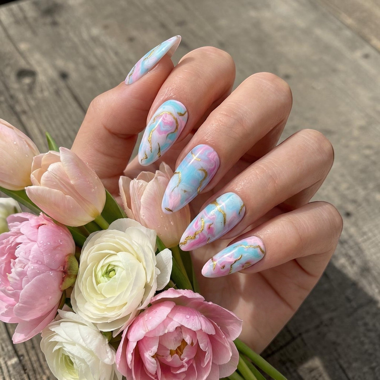 Auntie Cookies Nails: Pastel pink, blue, and purple marble press on nails with gold veining. Almond shape.