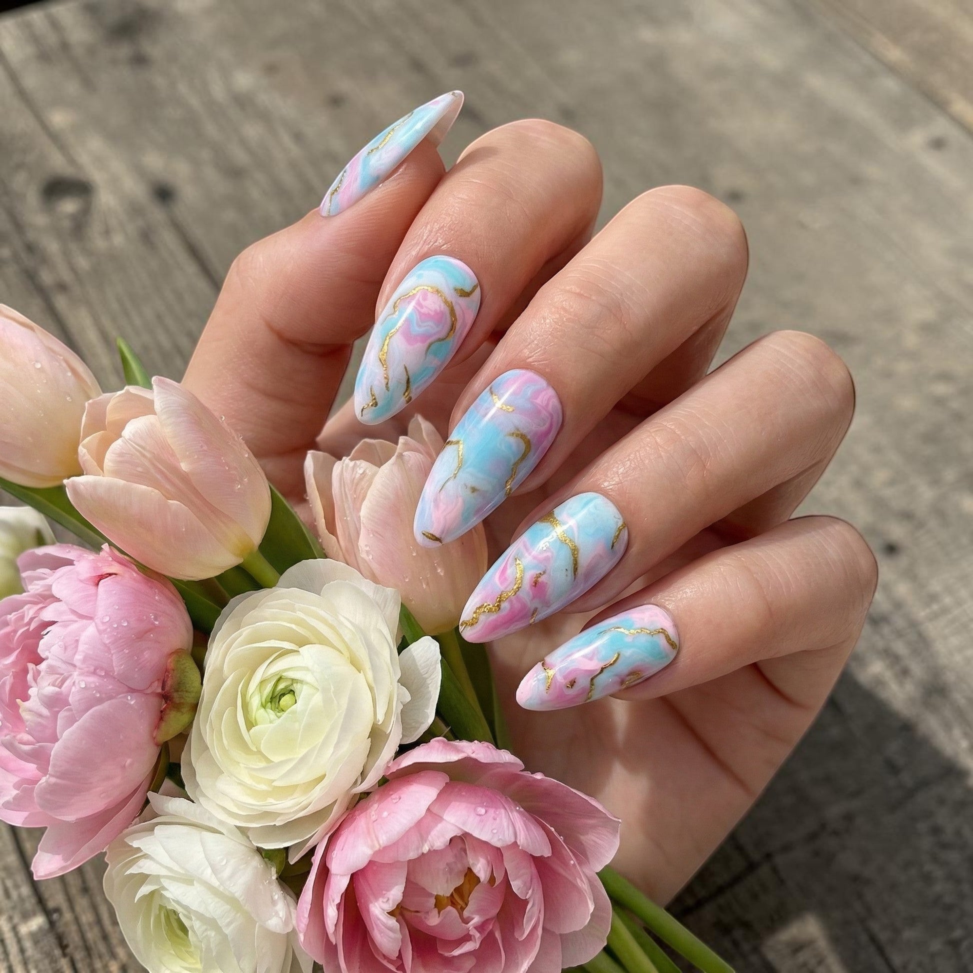 Auntie Cookies Nails: Pastel pink, blue, and purple marble press on nails with gold veining. Almond shape.