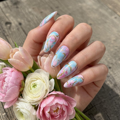 Auntie Cookies Nails: Pastel pink, blue, and purple marble press on nails with gold veining. Almond shape.