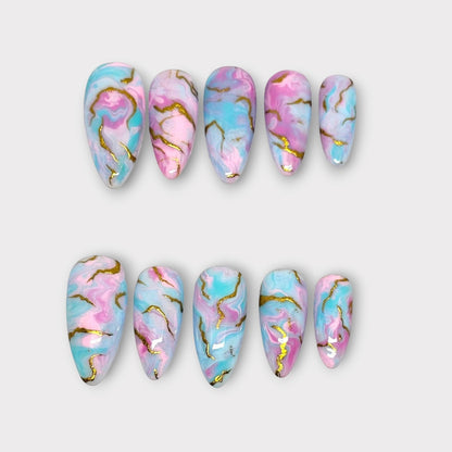 Auntie Cookies Nails pastel pink, blue, and white marble press on nails with gold accents. Almond shape.