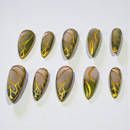 Auntie Cookies Nails Forest Fairy press on nails with green gradient base and metallic gold butterfly wing patterns.