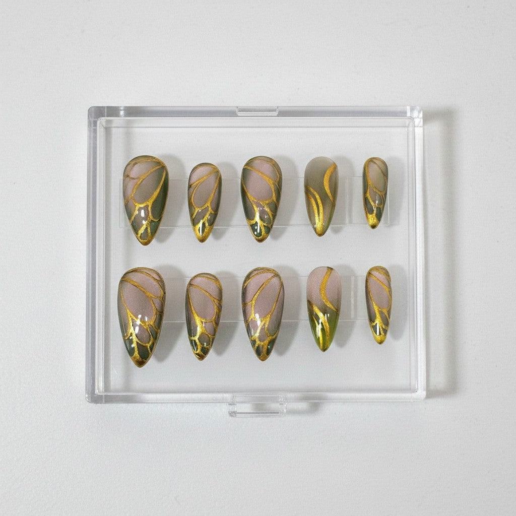 Auntie Cookies Nails Forest Fairy press on nails with green gradient, sheer base, and gold metallic wing patterns.
