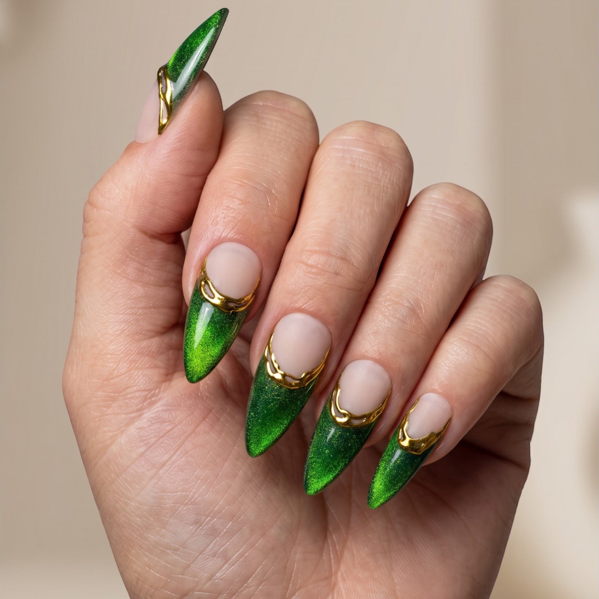 Auntie Cookies Nails almond press-on nails with emerald green cat-eye finish, nude base, and gold metallic French tips.
