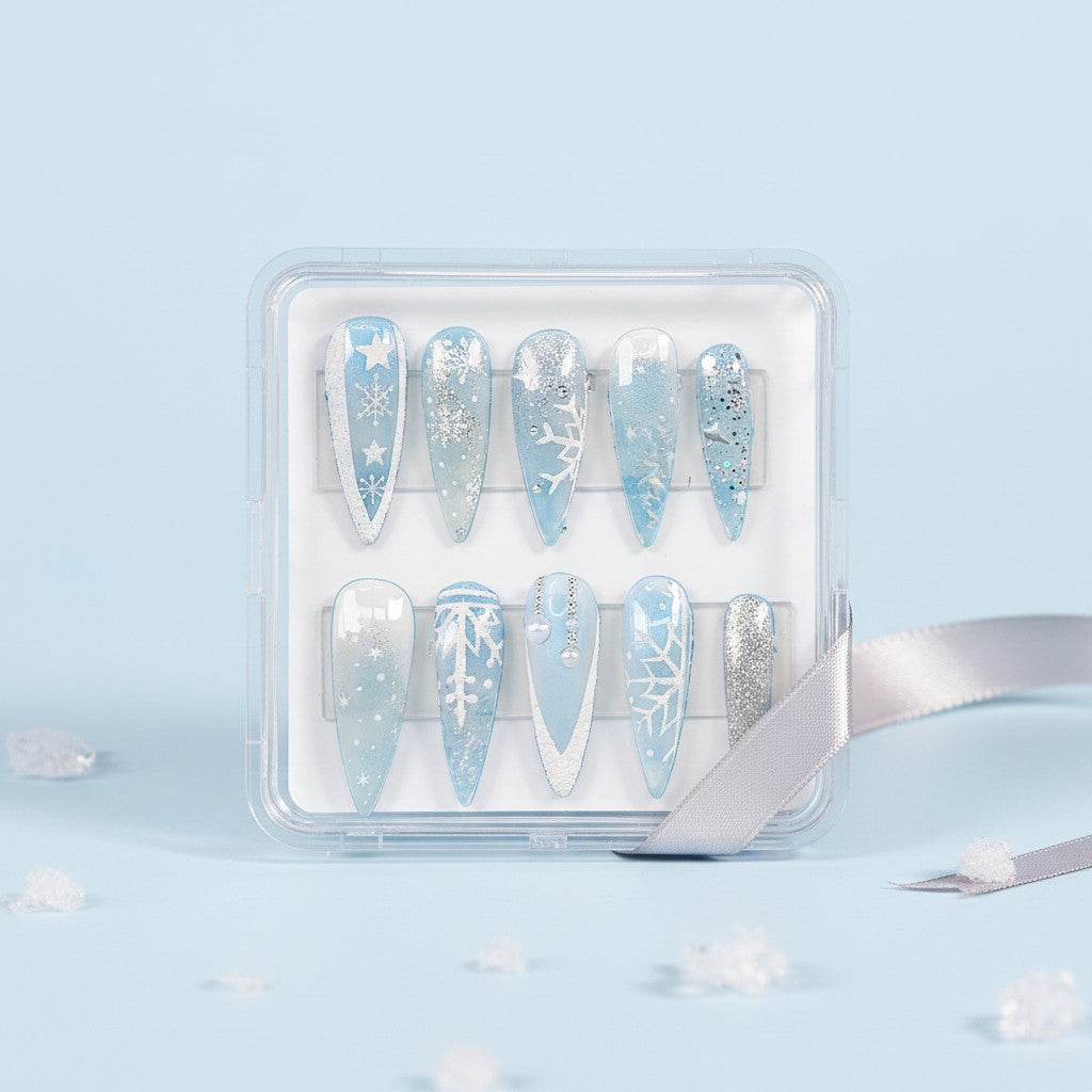 Auntie Cookies Nails Ice Queen press-on nails with snowflake designs, frosted finishes, and pearl accents in blue and silver.