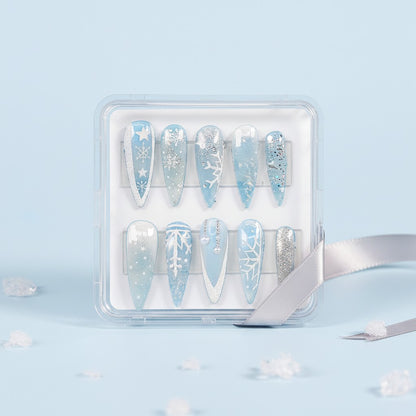 Auntie Cookies Nails Ice Queen press-on nails with snowflake designs, frosted finishes, and pearl accents in blue and silver.