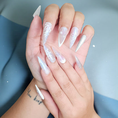 Auntie Cookies Nails Ice Queen stiletto press on nails with snowflake designs, glitter, and pearls in icy blue, silver, and white.