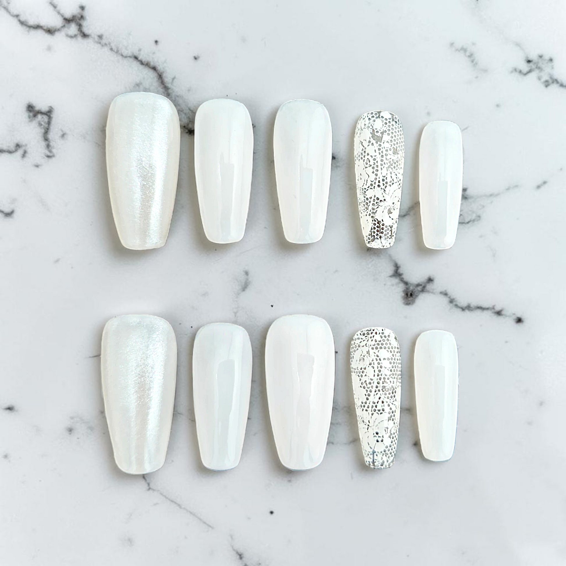 Auntie Cookies Nails ivory coffin press-on nails with pearlescent, glossy, and intricate lace accent designs.