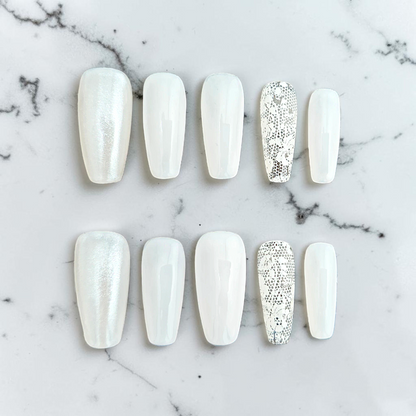 Auntie Cookies Nails ivory coffin press-on nails with pearlescent, glossy, and intricate lace accent designs.
