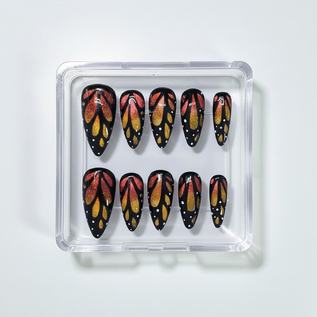 Auntie Cookies Nails Monarch butterfly press-on nails with orange and gold cat eye glitter and black wing detailing.