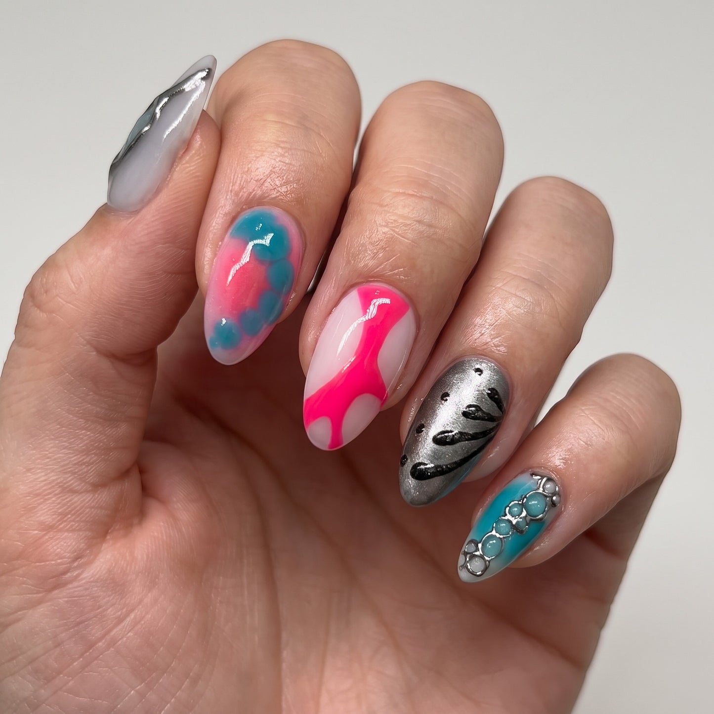 Auntie Cookies Nails Neon Aura press-on nails featuring neon pink, electric blue, and metallic silver 3D art designs.