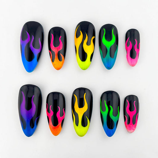 Auntie Cookies Nails press-on set featuring almond-shaped black nails with vibrant neon multi-colored flame designs.