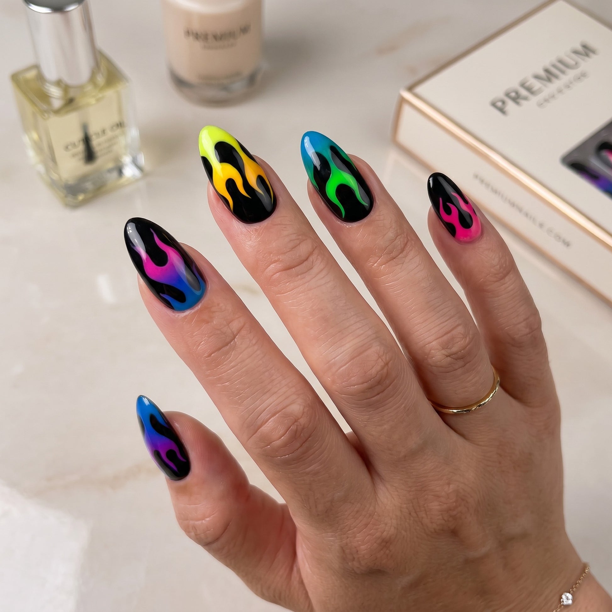 Auntie Cookies Nails almond press-on nails featuring a black base with vibrant neon gradient flame designs.