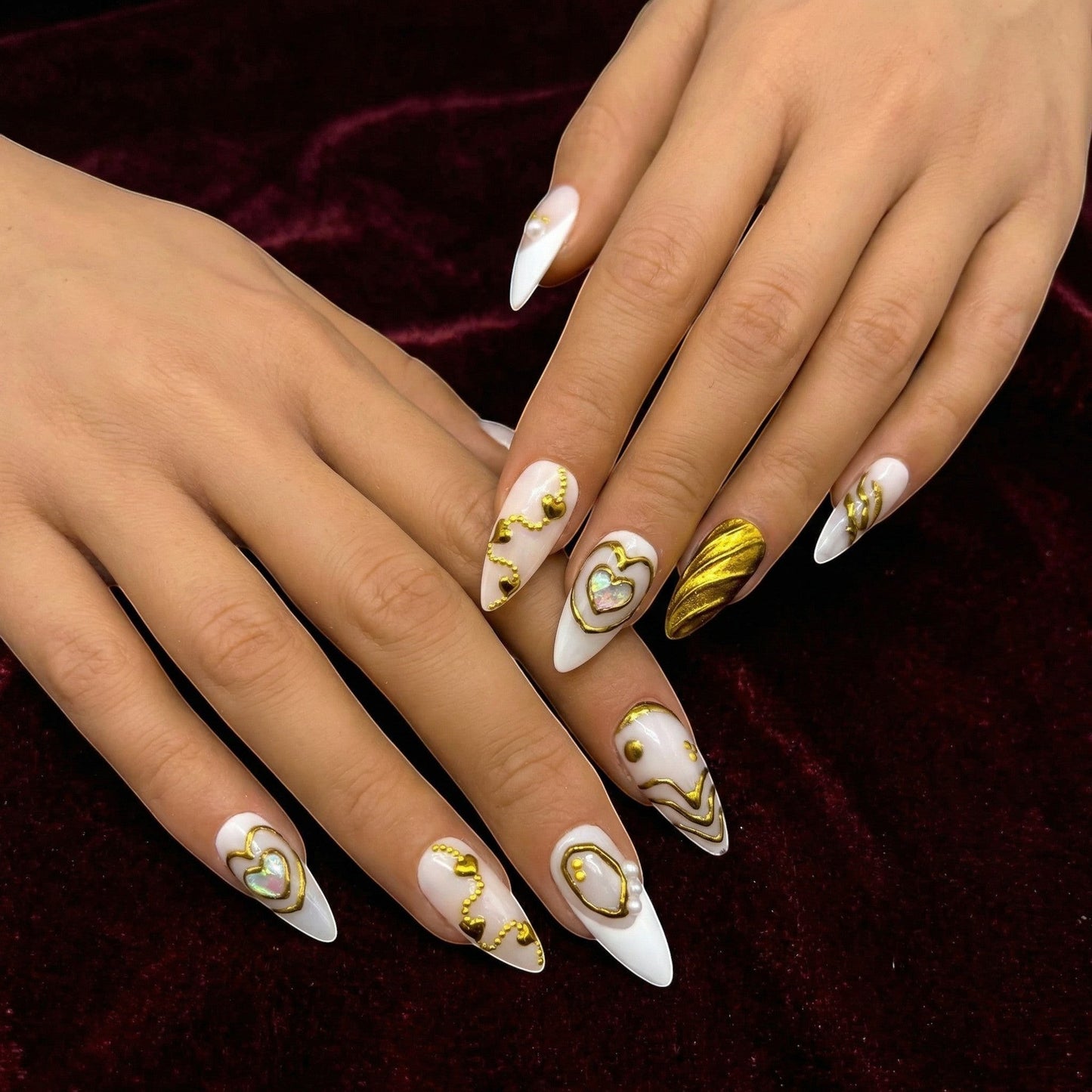 Auntie Cookies Nails Opulent Ivory press on nails with gold heart designs, pearls, and textured accents. Stiletto shape.
