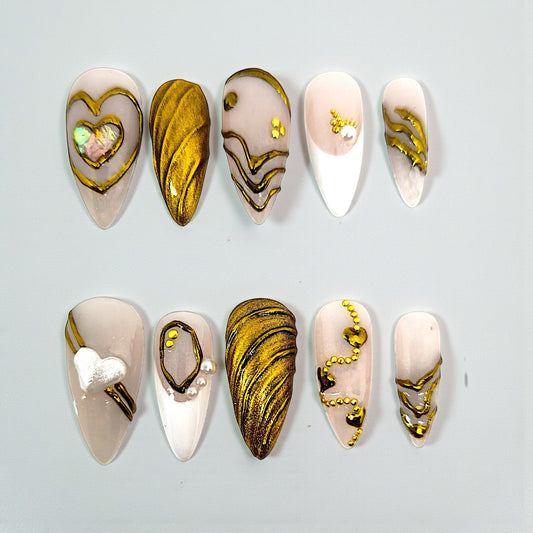 Auntie Cookies Nails Opulent Ivory press on nails with gold accents, heart designs, pearls, and textured finish.
