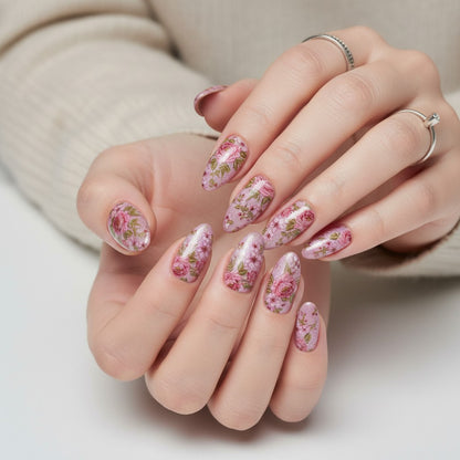 Auntie Cookies Nails Petal Prism Press On Nails feature a pink floral design with roses and blossoms on an iridescent pink base. Almond shape.