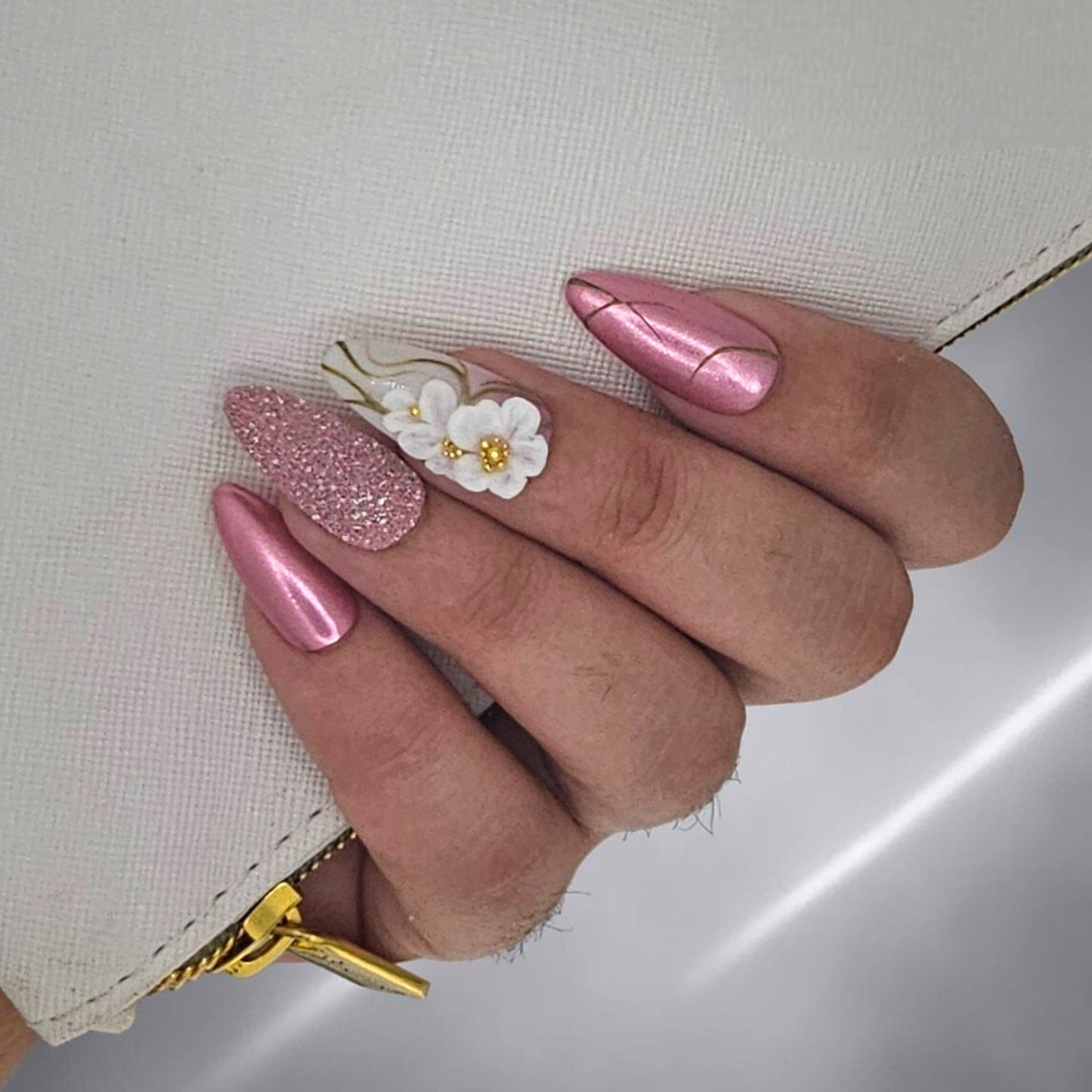 Auntie Cookies Nails: Pink metallic almond press-on nails with gold lines and 3D floral accent nail.