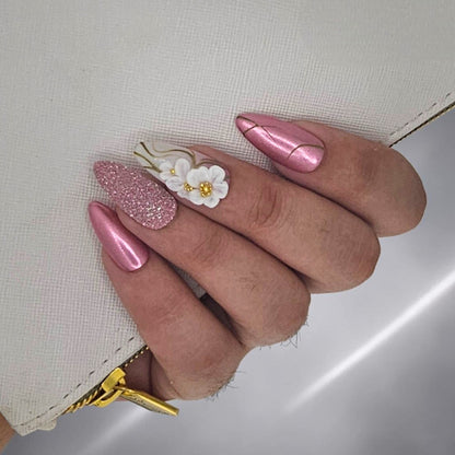 Auntie Cookies Nails: Pink metallic almond press-on nails with gold lines and 3D floral accent nail.