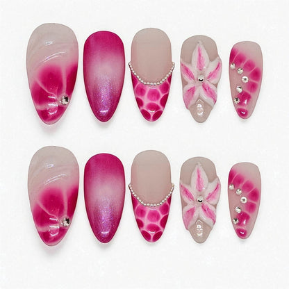 Auntie Cookies Nails: Pink ombre press on nails with floral 3D art, rhinestones, and pearl accents. Oval and almond shapes.