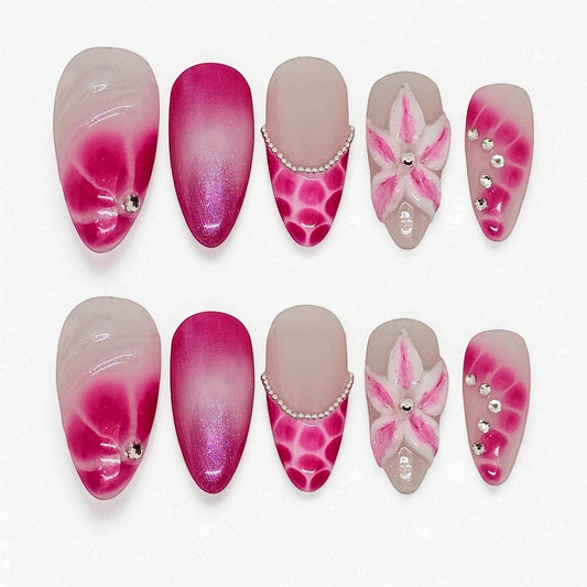 Auntie Cookies Nails: Pink ombre press on nails with floral 3D art, rhinestones, and pearl accents. Oval and almond shapes.
