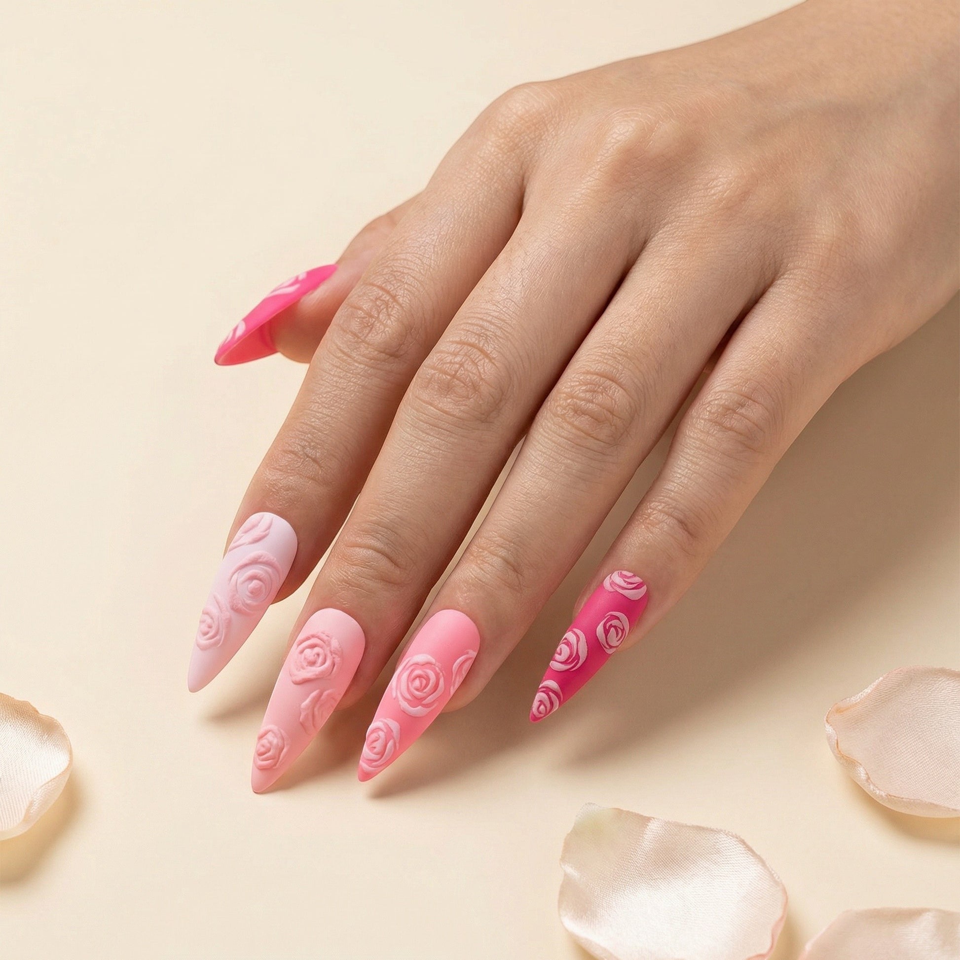 Auntie Cookies Nails: Pink stiletto press-on nails with embossed rose designs in varying shades of pink.