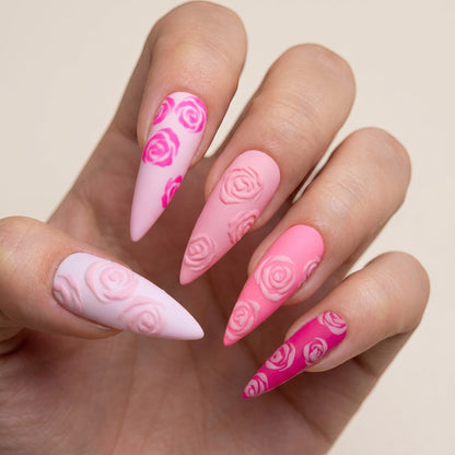 Auntie Cookies Nails almond-shaped press-on nails with a pink gradient, matte finish, and 3D embossed rose designs.