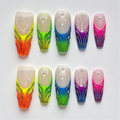 Auntie Cookies Nails: Set of 10 rainbow gradient press-on nails with glitter, pearl, and bead accents.