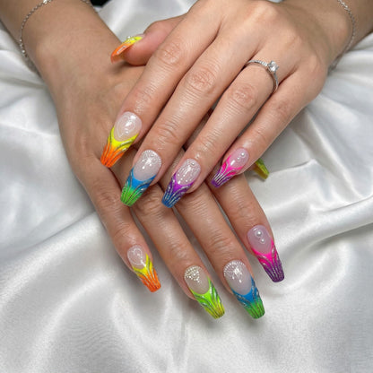 Auntie Cookies Nails: Long, coffin-shaped press-on nails with a rainbow gradient, glitter, pearls, and white bead detailing.