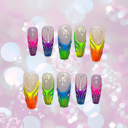 Auntie Cookies Nails: Vibrant gradient press-on nails with glitter, pearl, and bead accents in orange, green, blue, and purple.