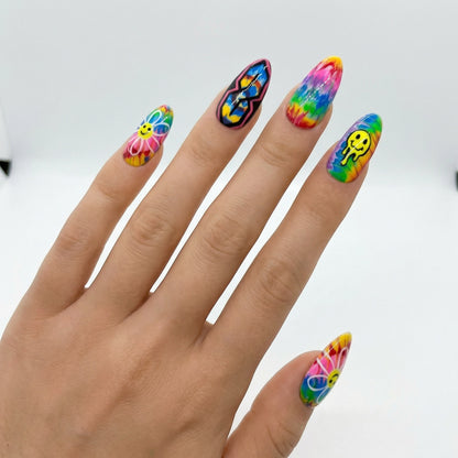Auntie Cookies Nails: Rainbow tie-dye press-on nails with smiley faces, peace signs, and psychedelic designs.