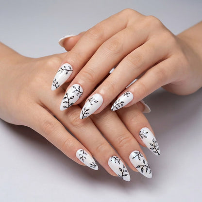 Auntie Cookies Nails white stiletto press-on nails with black branch and silver leaf design.