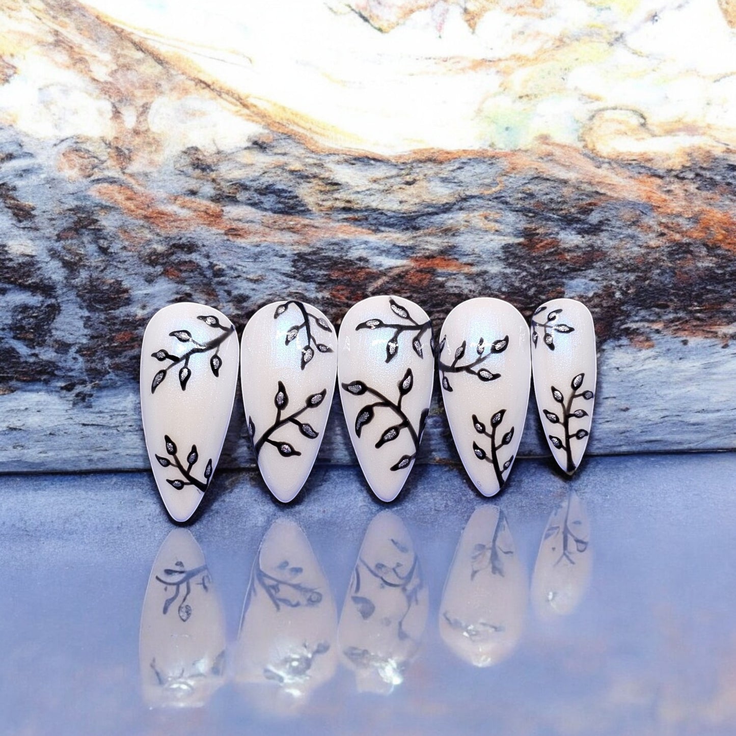 Auntie Cookies Nails: Shimmery white stiletto press-on nails with black branch and silver leaf design.