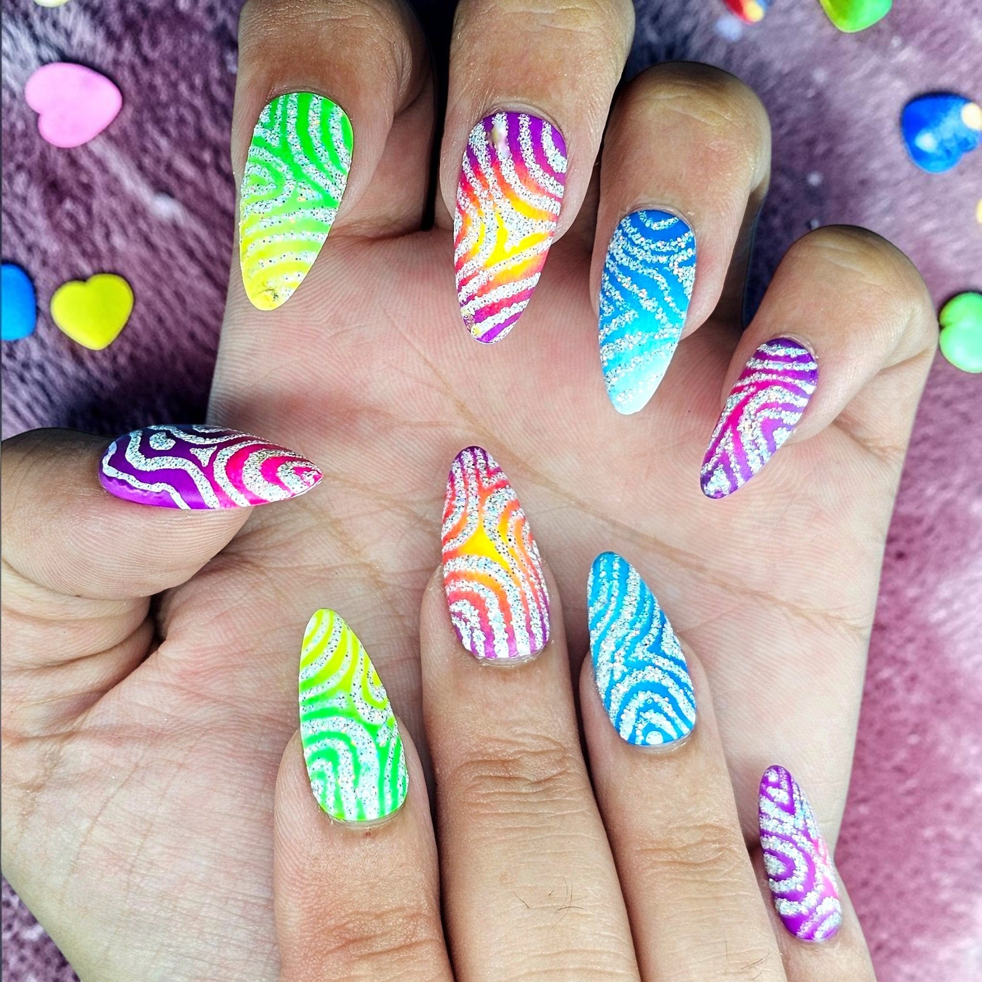 Auntie Cookies Nails Zebra Pop Parade press-on nails with rainbow glitter zebra print on almond-shaped tips.