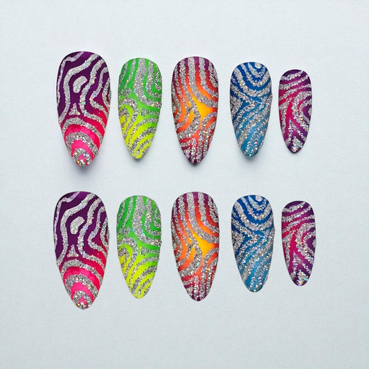 Auntie Cookies Nails Zebra Pop Parade press-on nails with rainbow gradients, silver glitter, and zebra print patterns.